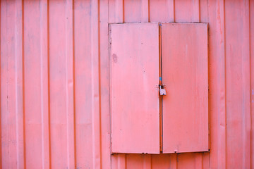 metal shutters closed on the lock. pink garage door locked. cargo ship container texture. copy space for your text