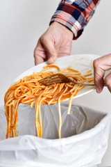 young man throwing leftovers to the trash bin