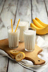 Three glasses of banana milkshake on the wooden table.