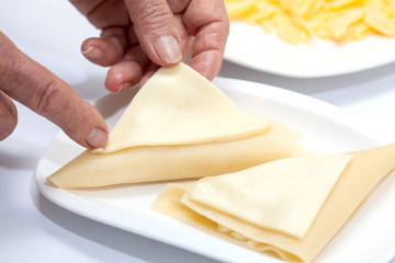 Cubriendo los triángulos para lasagna parmesana con queso