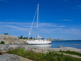 Moored sailboat at small archipelago island in the sun