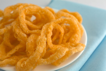 Crunchy onion rings on a white plate and blue napkin.