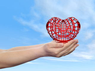 Conceptual human hand with heart and blue sky