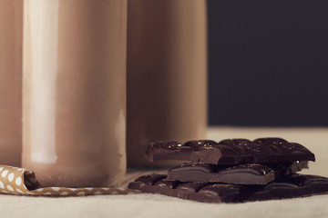 Cold chocolate milkshake in tall glass with ice