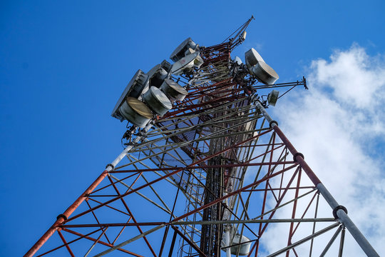 Cellphone radio antenna mast with bright blue sky in the background
