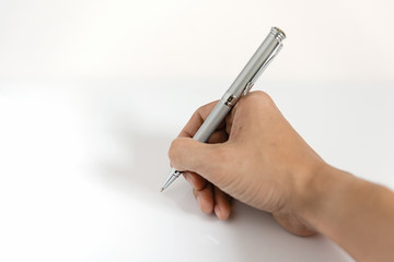 Close up of man hand writing with metallic pen on white background