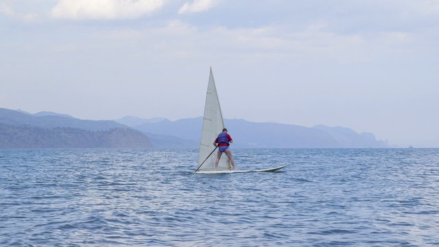 Man getting windsurfing lessons along shoreline in a sea