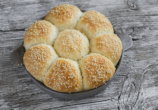 Homemade bread rolls in a vintage pan on wooden background