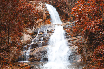 Wonderful autumn waterfall in deep forest at national park, Thailand