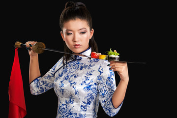Young asian beauty is holding sushi on katana