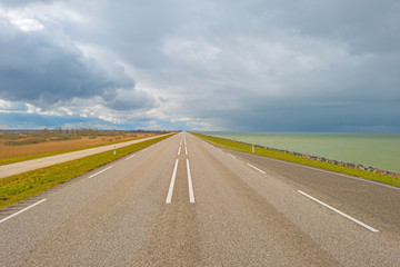 Road over a dike along a lake in winter