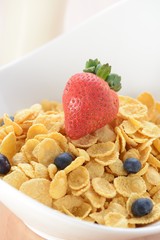 bowl of cereals with strawberry and blueberries