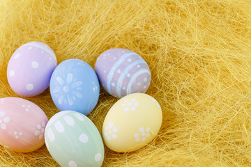 Fototapeta na wymiar Easter homemade painted eggs on yellow straw.