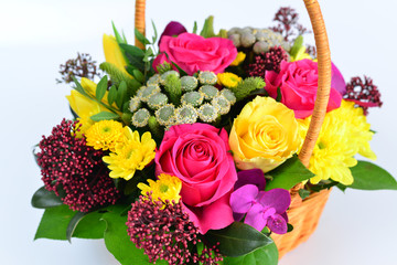 Beautiful flowers in wicker basket on  light background