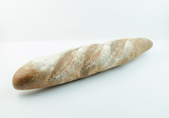 Long loaf with flour sprinkled on a white background