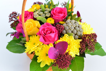 Beautiful flowers in wicker basket on  light background