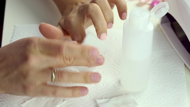 Professional nails care in process - dehydration of female nail after gel polish application procedure

