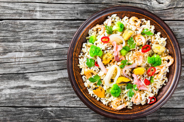 rice with seafood and broccoli in a bowl, top view