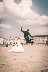 Sposo felice che salta in alto di fronte alla sposa - Trieste (Italia) Molo Audace