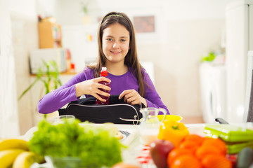Girl puts a snack in a bag for school
