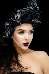 Fototapeta premium Portrait of a Young Woman with black flower Wreath on black background