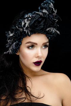 Portrait of a Young Woman with black flower Wreath on black background