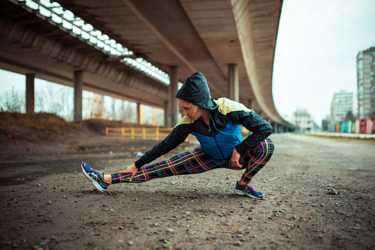 Young woman stretching her body after workout and jogging.