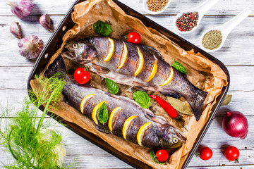 raw trouts fish on a baking dish, top view