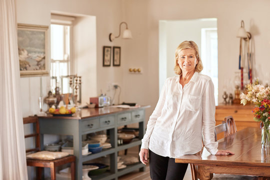 Senior woman looking relaxed in her bright rustic kitchen