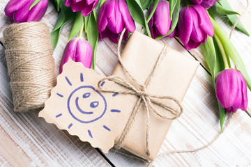 Sun with happy face and bouquet of tulips on wooden background