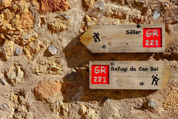 Wooden signpost for hiking on the rock wall, Deia,Majorca,Spain
