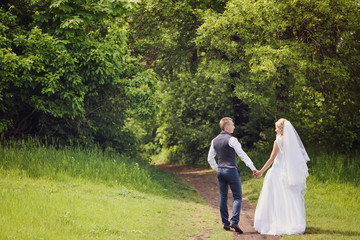 Fototapeta premium Young wedding couple enjoying romantic moments outside on a summer meadow