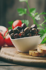 Olive with tamato and parsley on the wooden table