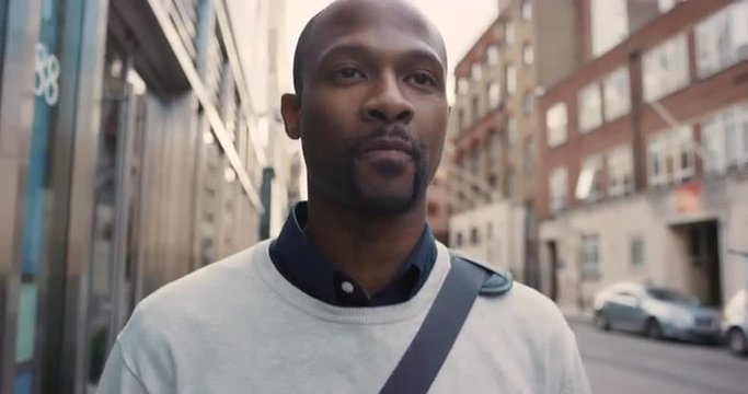 African American businessman walking through city 