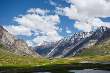 road to moutains with clouds in blue sky