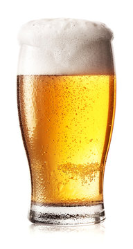Glass of light beer with foam and drops