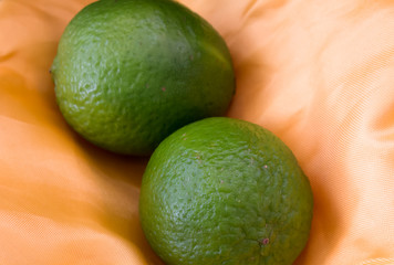Limes on yellow fabric background 