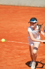Little girl playing tennis, chasing the ball