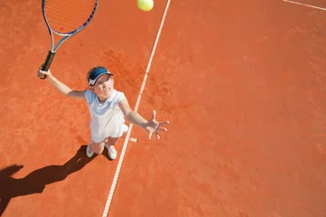 Poster Tennis serve. Junior level player in action, viewed from above © Microgen