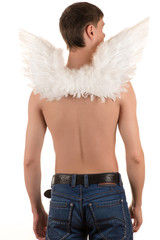 topless man in blue jeans with white angel wings on his back and arms down looking to the side
