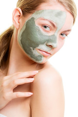 Woman in clay mud mask on face isolated on white.