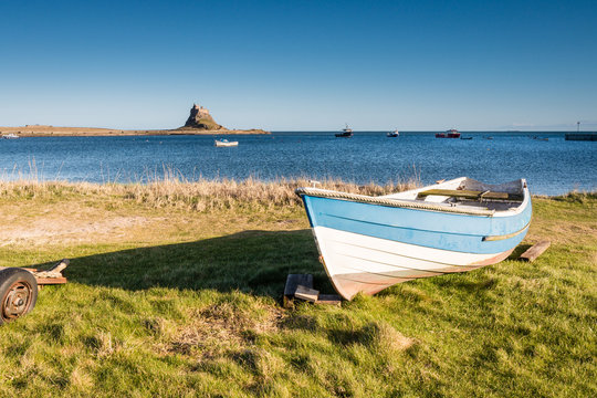 Lindisfarne Harbour and Castle with rowing boat in the foreground