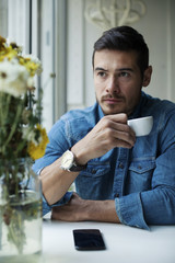 Handsome Man Drinking coffee From Cup Indoor