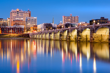 Obraz premium Harrisburg, Pennsylvania skyline with the historic Market Street Bridge reflected on the Susquehanna River at dusk