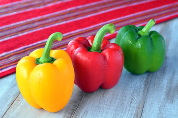 Yellow, red and green capsicum on a wooden table