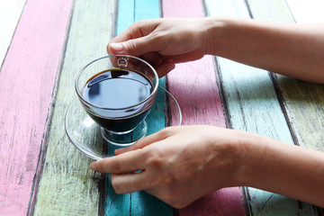 Fototapeta na wymiar hand holding coffee cup on colorful table