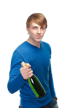 handsome young man in a blue sweater with a bottle of champagne