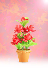 The artificial flower in the pot on white background