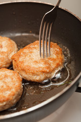 Fresh juicy grilled meat patties in a frying pan