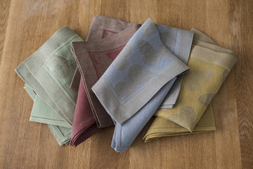 Folded Placemats and Napkins of Various Colors on Wooden Surface